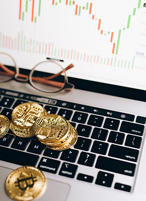 A computer with graph and coins on keyboard representing CMMS savings.