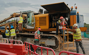 Maintenance workers conducting maintenance on construction equipment for operational reliability. 