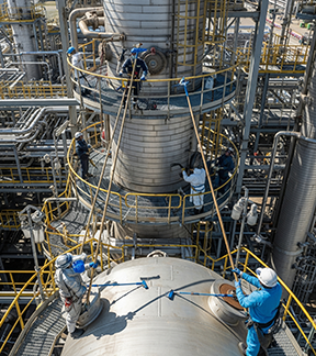 Ethanol maintenance workers take readings on distillation towers.