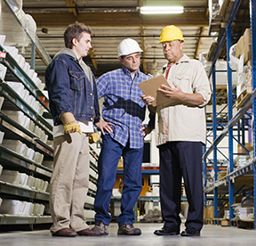 Two maintenance technicians receiving feedback from a supervisor on a specific CMMS job.