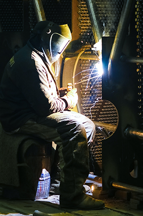 Welder conducting preventive maintenance from a CMMS work order.