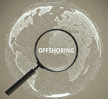 A globe with a magnifying glass over it with offshoring in the middle