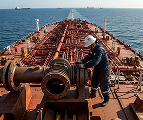 A maintenance worker on an oil tanker completes a CMMS work order