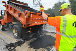 A road crew work with truck finishes a CMMS work order.